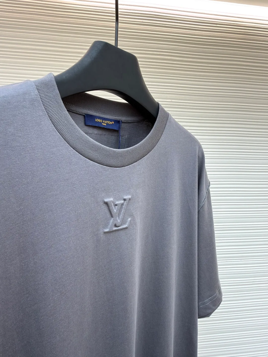 LOUIS VUITTON Concave embossed round neck short sleeves ●Original version: Purchased and developed in 5010 ●Item number: 1681360-A00 ●Fabric: plain knitted fabric ●Technology: embossed embossed production ●Color: gray ●Version: fitted version ●Weight: about 205 grams ●Size: High-count combed cotton yarn eliminates most of the short hairiness through compact spinning process, making the yarn smoother and stronger. The woven fabric structure is extremely dense, flat and soft, with excellent anti-pilling ability and durability, while retaining the natural advantages of pure cotton, which is breathable and skin-friendly. The neckline is made of 32S 1x1 rib with a weight of 300g. The finer yarn count creates a more delicate and tight thread, which provides better elasticity and deformation resistance than ordinary ribs, ensuring that the neckline can still remain stiff after being put on and taken off many times. It contains an innovative process of silicone lining. The concave and convex embossing process is heated and shaped by the upper and lower dies. The rollers press the fabric at a certain temperature, and the three-dimensional hierarchical convex surface is produced through mechanical embossing. This makes the embroidered patterns not only three-dimensional and full, but also uniquely soft and elastic to the touch, which is completely different from traditional stiff embroidery. The support of silicone also ensures that the pattern is not prone to wrinkles and deformation after washing, achieving a combination of visual novelty and process durability. The overall wiring is straight and delicate, the fabric is comfortable and soft, and the color is consistent without color difference. It can be matched with the same style to create a fashionable look and control various occasions. Customized accessories, complete with three standards, same style for men and women!